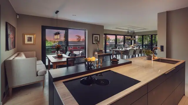 Lekkert kjøkken med stor øy på 3 meter fra Fresh Interiør med BORA platetopp med integrert ventilator. Benkeplate Silestone og nedfelt messingvask med messingarmatur