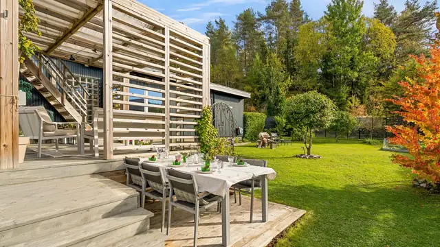 Trivelig terrasse med plass til langbord, samt trapp ned til hagen